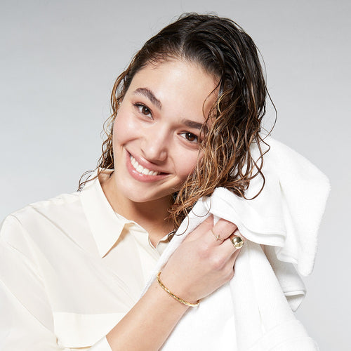 Woman squeezing water out of wet curly hair