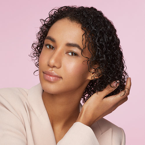 Woman with wet curly hair squeezing out the excess water before drying