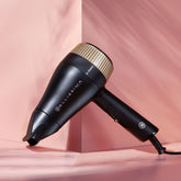 Bellissima B Travel hair dryer against a pink background